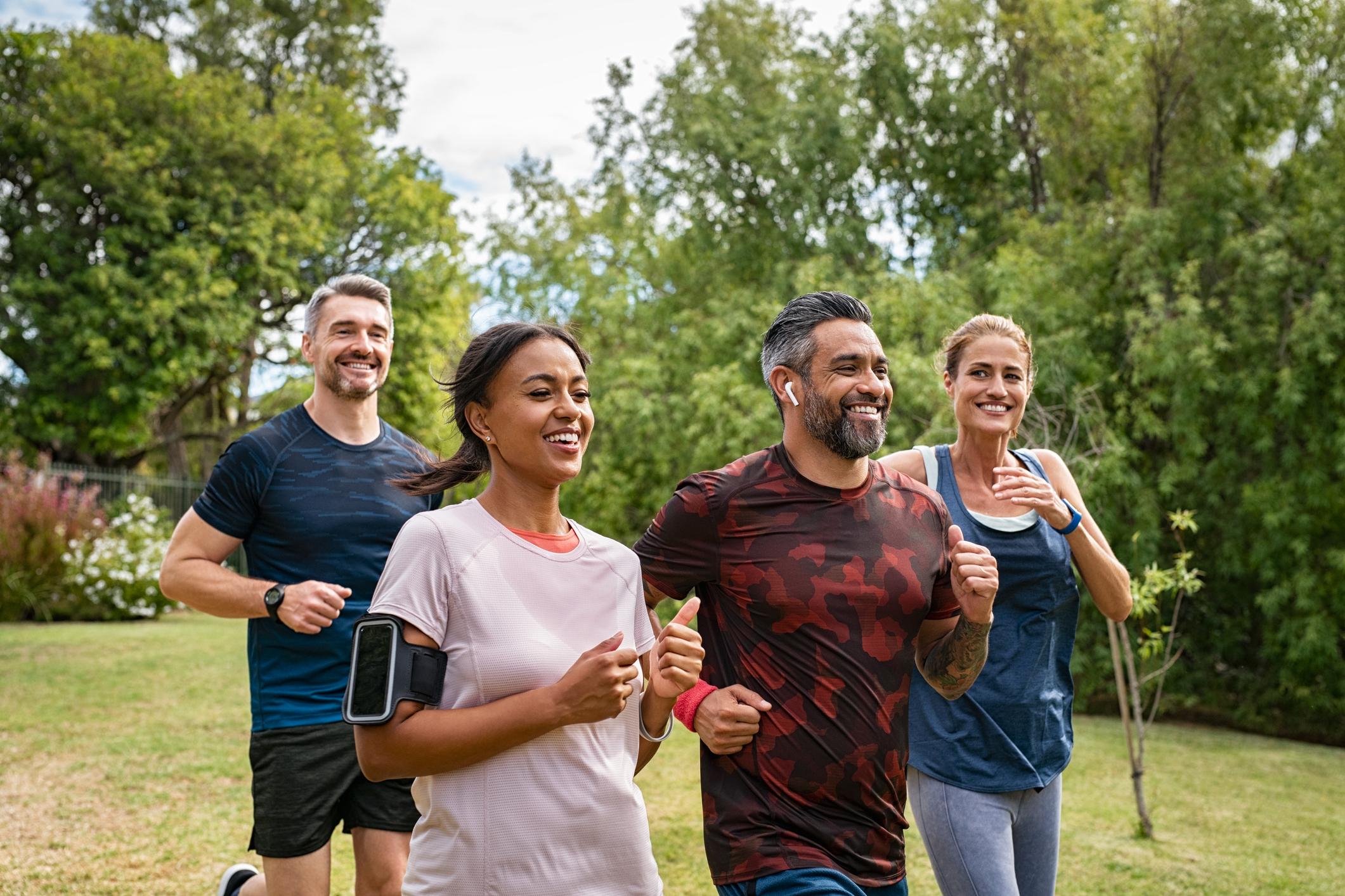 Couple jogging together in a park on a sunny day.